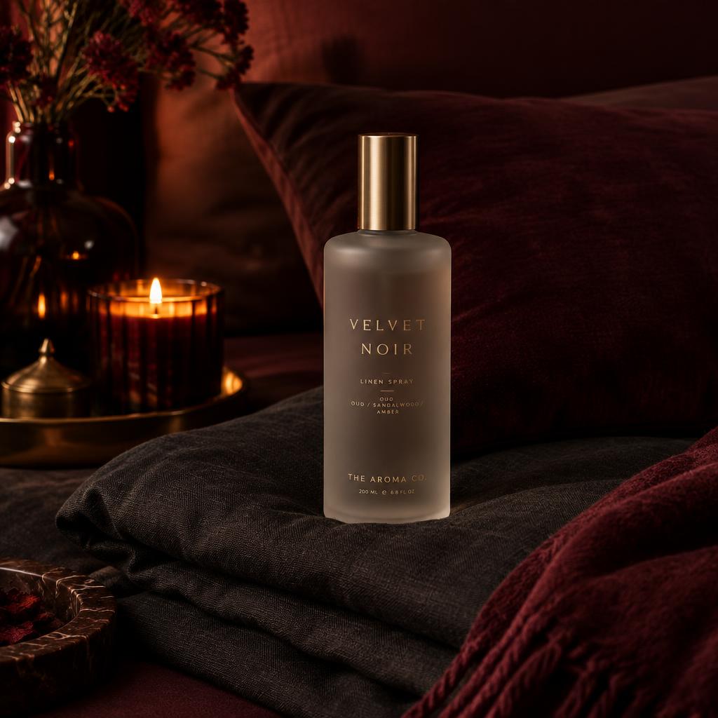 Frosted linen spray bottle on folded dark bedding